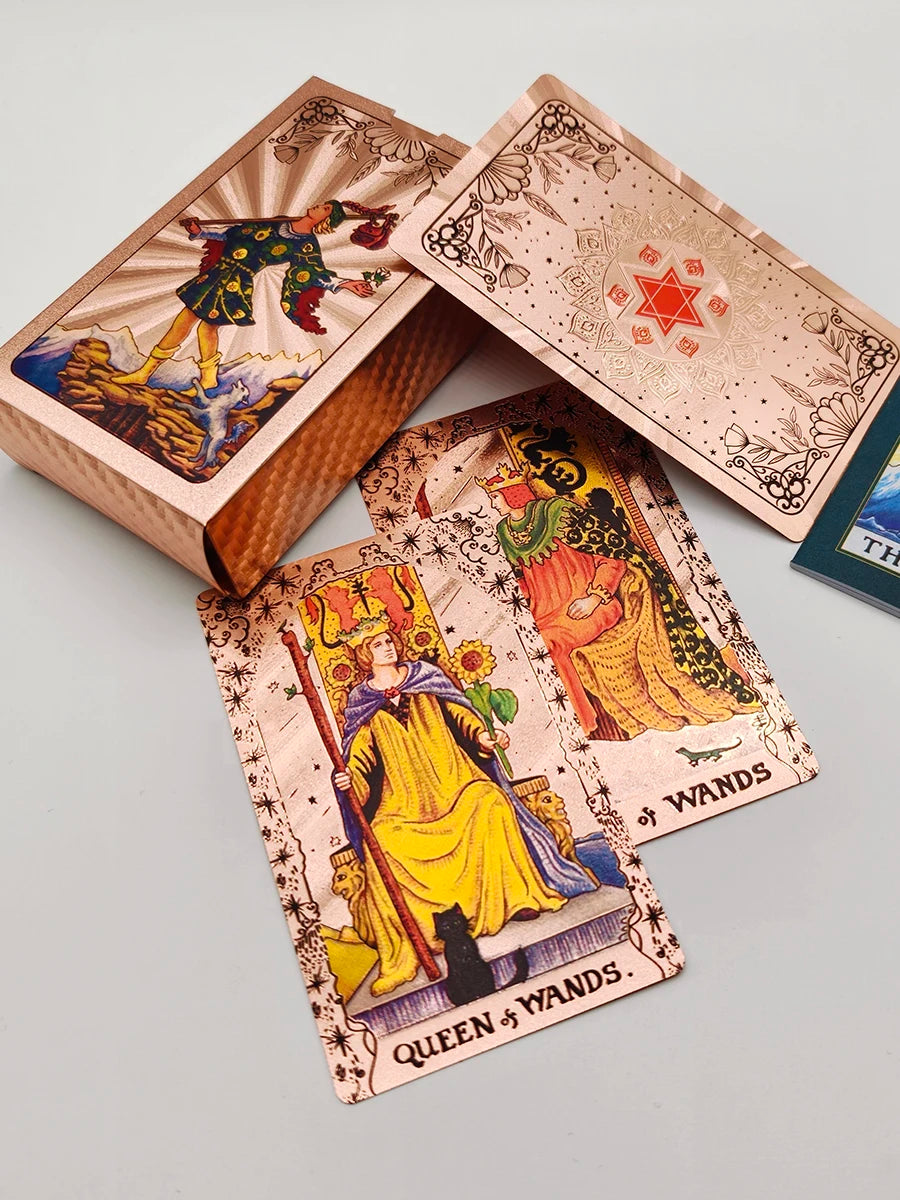 A deck of gold foil tarot cards and a guidebook are displayed in open packaging.