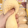 Eine Hand hält ein gelbes, strukturiertes Stressballspielzeug in Form einer Erdnuss.