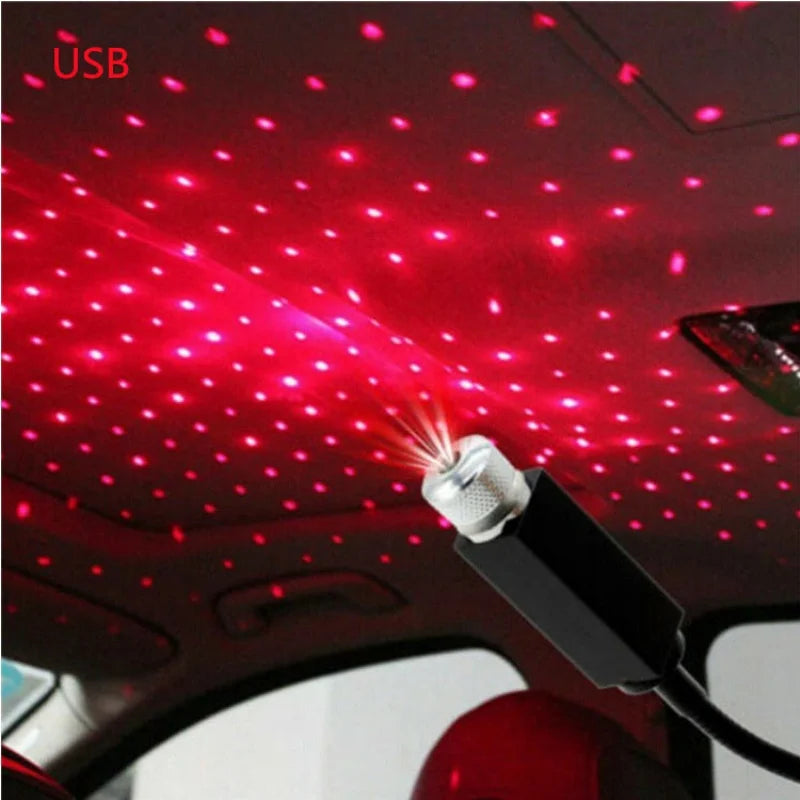 A portable LED projection lamp is shining red stars onto a car's interior ceiling.