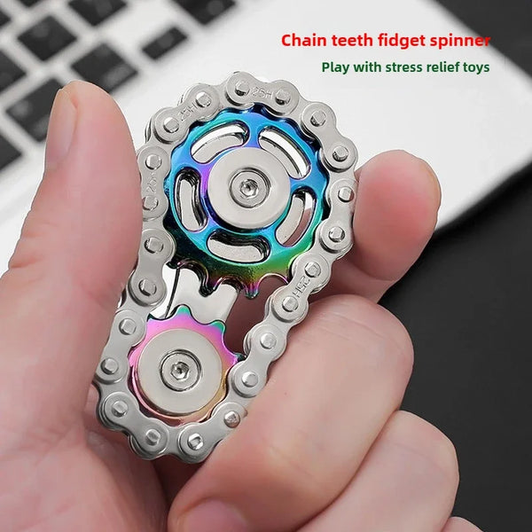 Una mano sostiene un juguete de spinner con dientes de cadena metálica plateada e iridiscente.