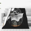 A black blanket featuring a silhouette of a white bat-like creature against a moonlit background.