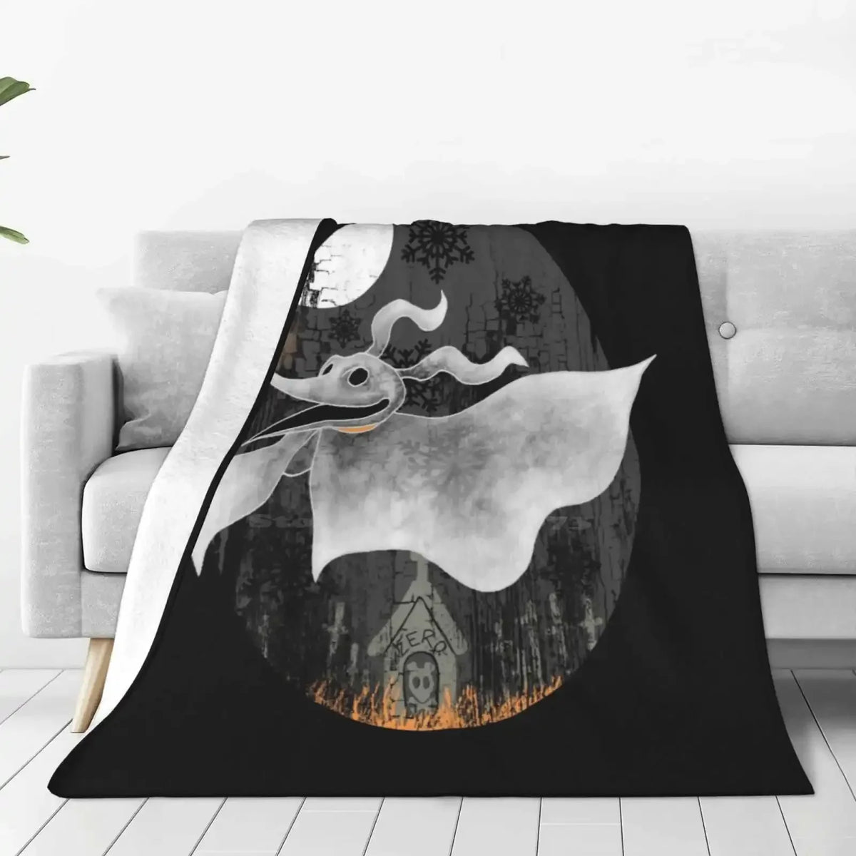 A black blanket featuring a silhouette of a white bat-like creature against a moonlit background.