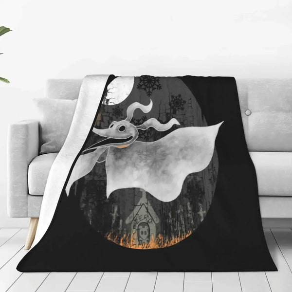 A black blanket featuring a silhouette of a white bat-like creature against a moonlit background.