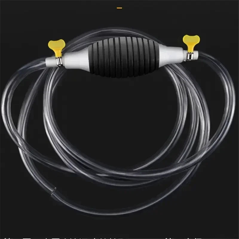 A manual siphon pump with a black body, silver nozzle, and clear tubing is shown against a dark background.