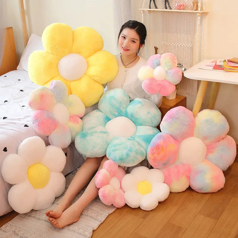 A collection of yellow and pink fluffy sunflower plush pillows displayed on a wooden floor.