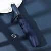 A dark blue automatic foldable umbrella with a silver accent is shown against a deep blue background.