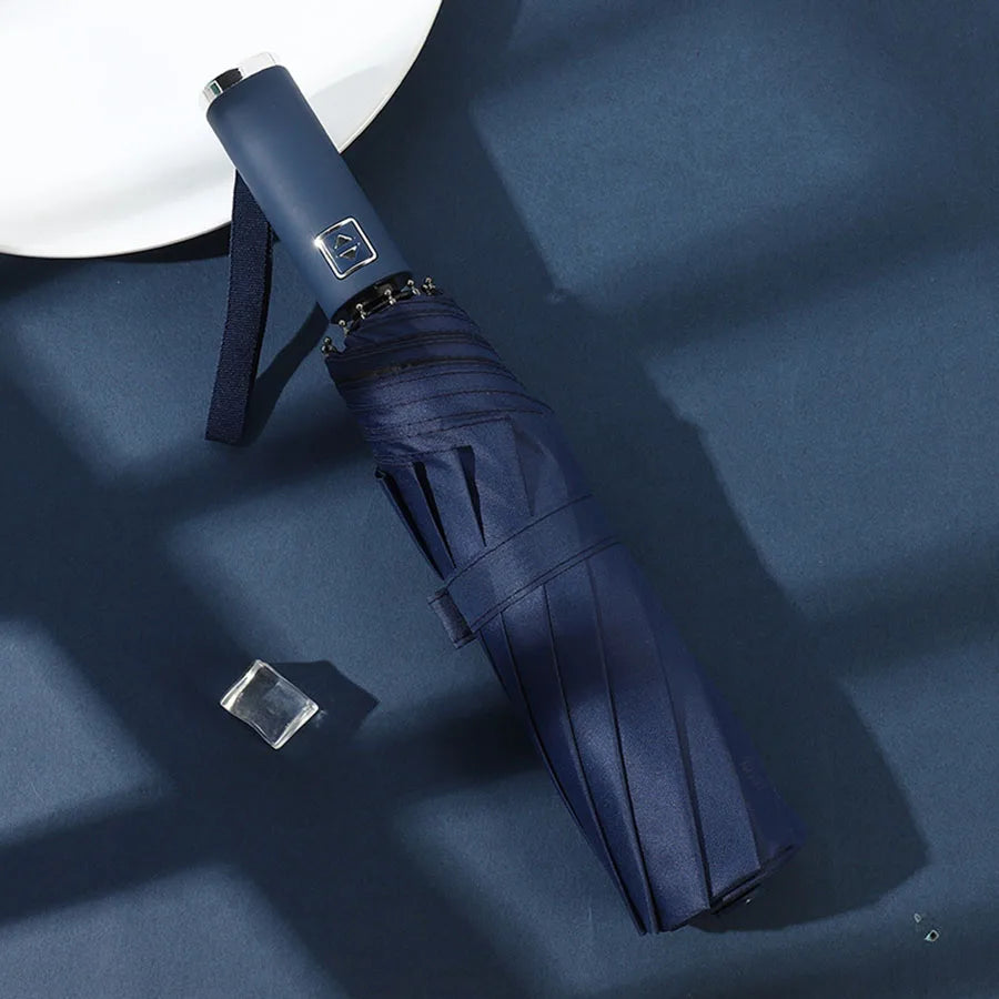 A dark blue automatic foldable umbrella with a silver accent is shown against a deep blue background.