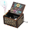 A dark wooden music box with a lid featuring the text You Are My Sunshine and decorative floral patterns.