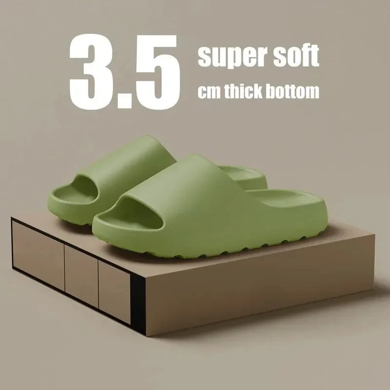 A pair of light green cloud thick-soled EVA slides resting on a brown wooden surface.