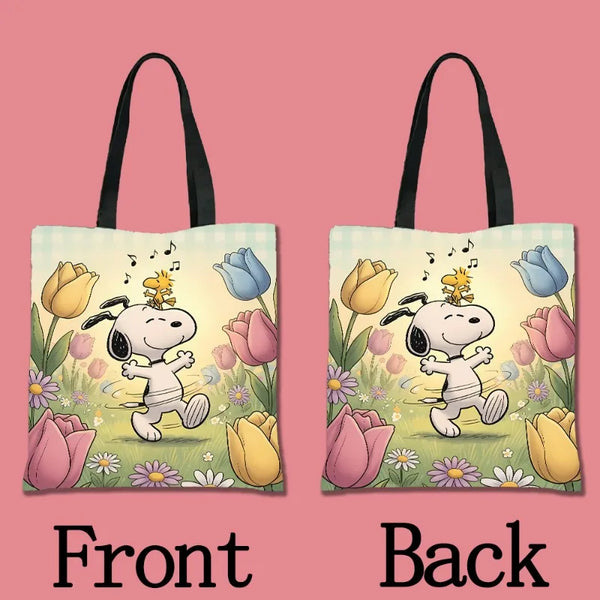 A canvas tote bag featuring a Snoopy cartoon design with yellow and purple flowers on a light green background.
