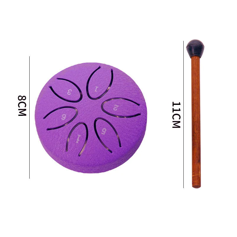 Purple mini steel tongue drum with mallets and a wooden stick, showing the instrument's size.