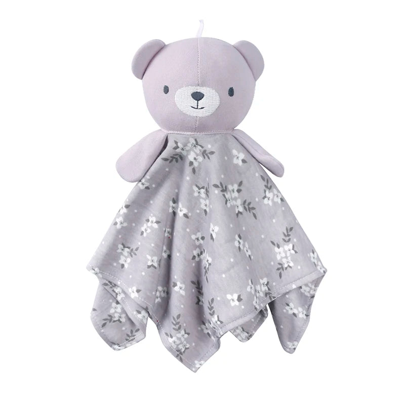 A soft lavender teddy bear stuffed animal with a floral patterned blanket.