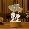 A silhouette of two cartoon figures holding heart-shaped balloons on a light-up acrylic display stand.