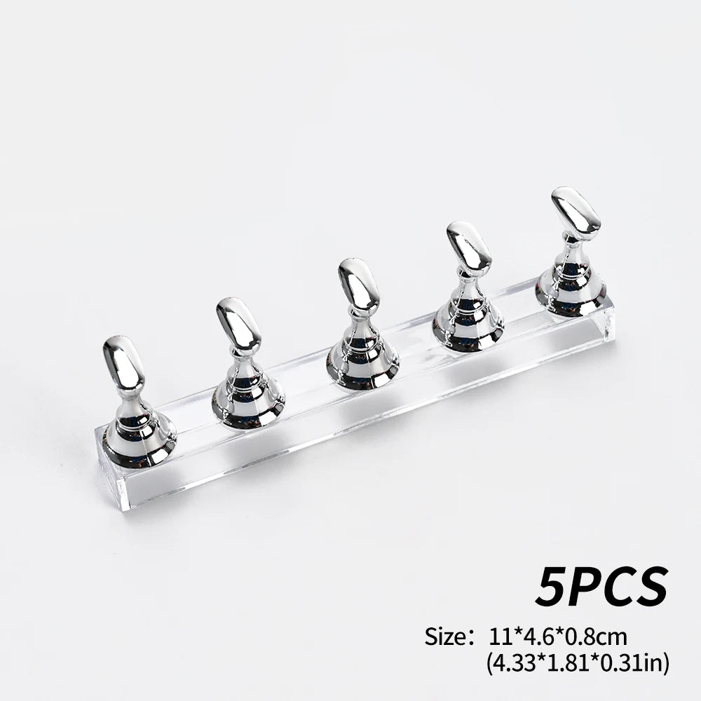 Five silver reusable nail glue clay pegs displayed on a clear acrylic shelf for fixing items.
