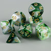 A set of seven green and white marbled polyhedral dice, including d10s and a triangle, scattered on a gray surface.