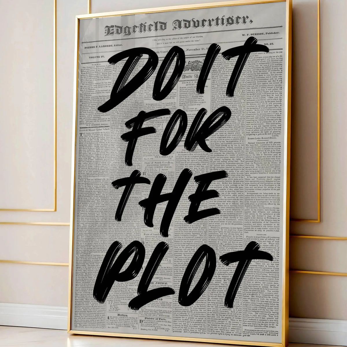 A framed canvas print featuring a vintage newspaper style quote that reads DO IT FOR THE PLOT in black ink on off-white paper