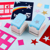 A light blue postage stamp embossing punch is shown next to colorful paper stamps and a card with a rainbow design.