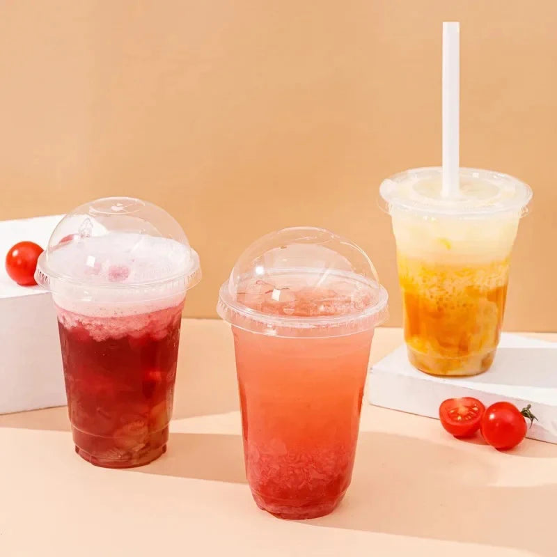 Three clear plastic cups filled with colorful iced drinks are displayed on a light surface.
