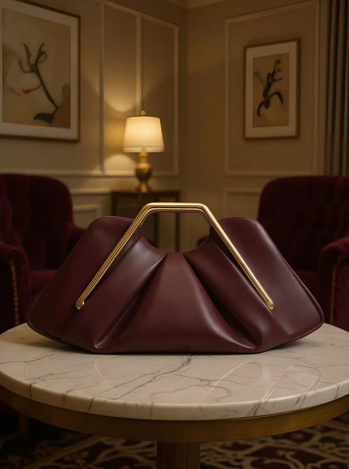 A deep burgundy soft PU leather crossbody bag resting on a marble table in a warmly lit room.