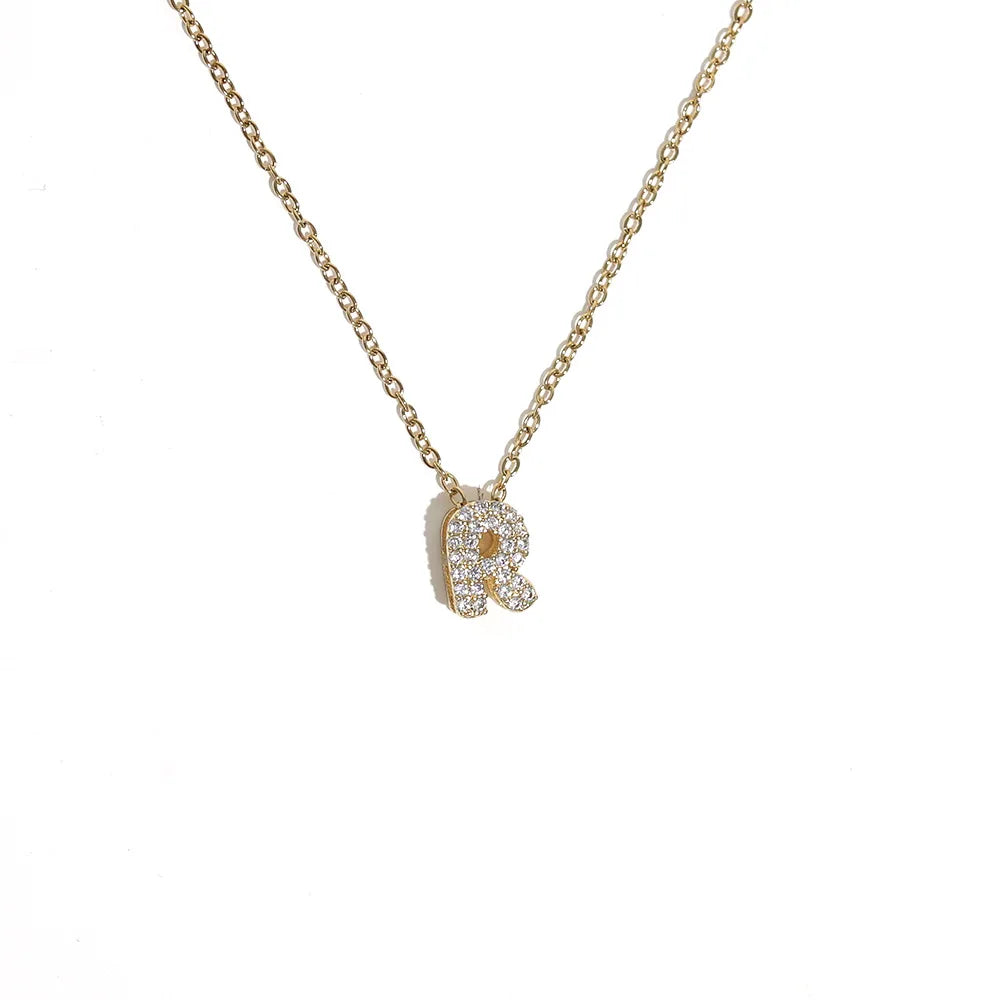 Collier de chaîne en or avec pendentif de lettre initiale scintillant.