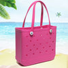 Helle pinke, portable EVA-Strandtasche mit perforierten Seiten auf einem Sandstrand mit blauem Ozean im Hintergrund.