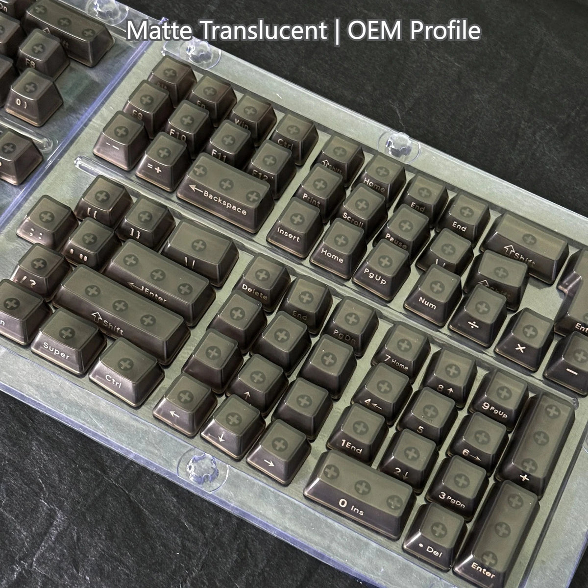 A close-up view of translucent OEM profile keycaps for a mechanical keyboard, showing various keys and labels.