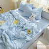 Light blue breathable summer seersucker quilt with white pillows and a yellow tag on a bed