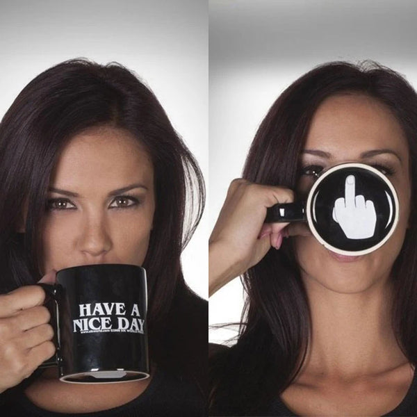 Une femme tient une tasse à café noire avec l'inscription HAVE A NICE DAY et fait un geste de doigt d'honneur.