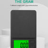 A black pocket digital scale displaying 0.00 grams on a bright green screen.