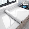 Roll of white marble peel-and-stick film for kitchen backsplash installation