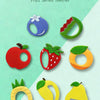 A collection of fruit-shaped silicone teethers for baby teeth relief, including apple, strawberry, lemon, and pear.