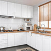 A modern kitchen featuring white cabinetry, light wood countertops, and a window with wooden blinds.