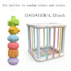 A Montessori rainbow grasping ball with rattle, teether, and shape sorter in various colors.