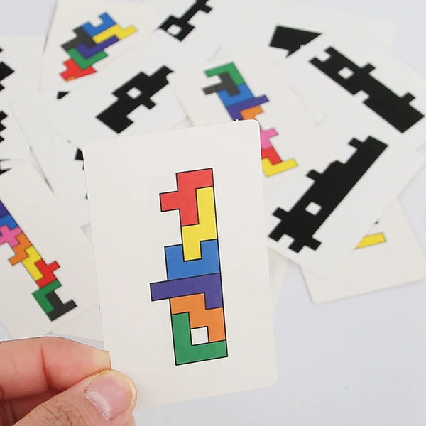A hand holds a wooden shadow matching puzzle card featuring colorful geometric shapes.