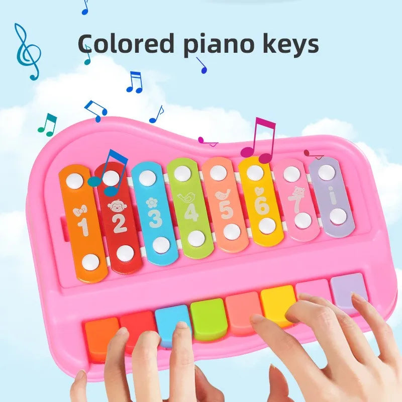 A hand is playing colored piano keys on a pink xylophone for toddlers.