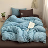 A blue and white striped duvet cover set with a dark brown pillow on a bed.