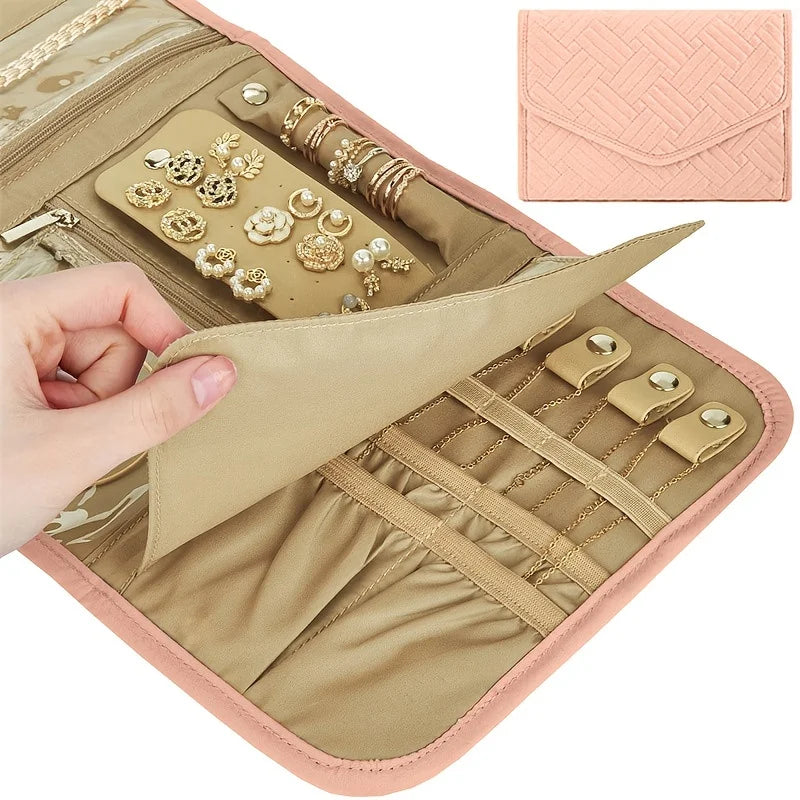 A beige foldable waterproof jewelry roll with decorative findings and a pink cosmetic pouch.