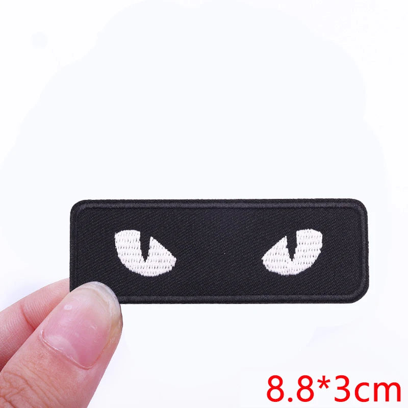Black iron-on letter patches featuring white embroidered designs for clothing customization