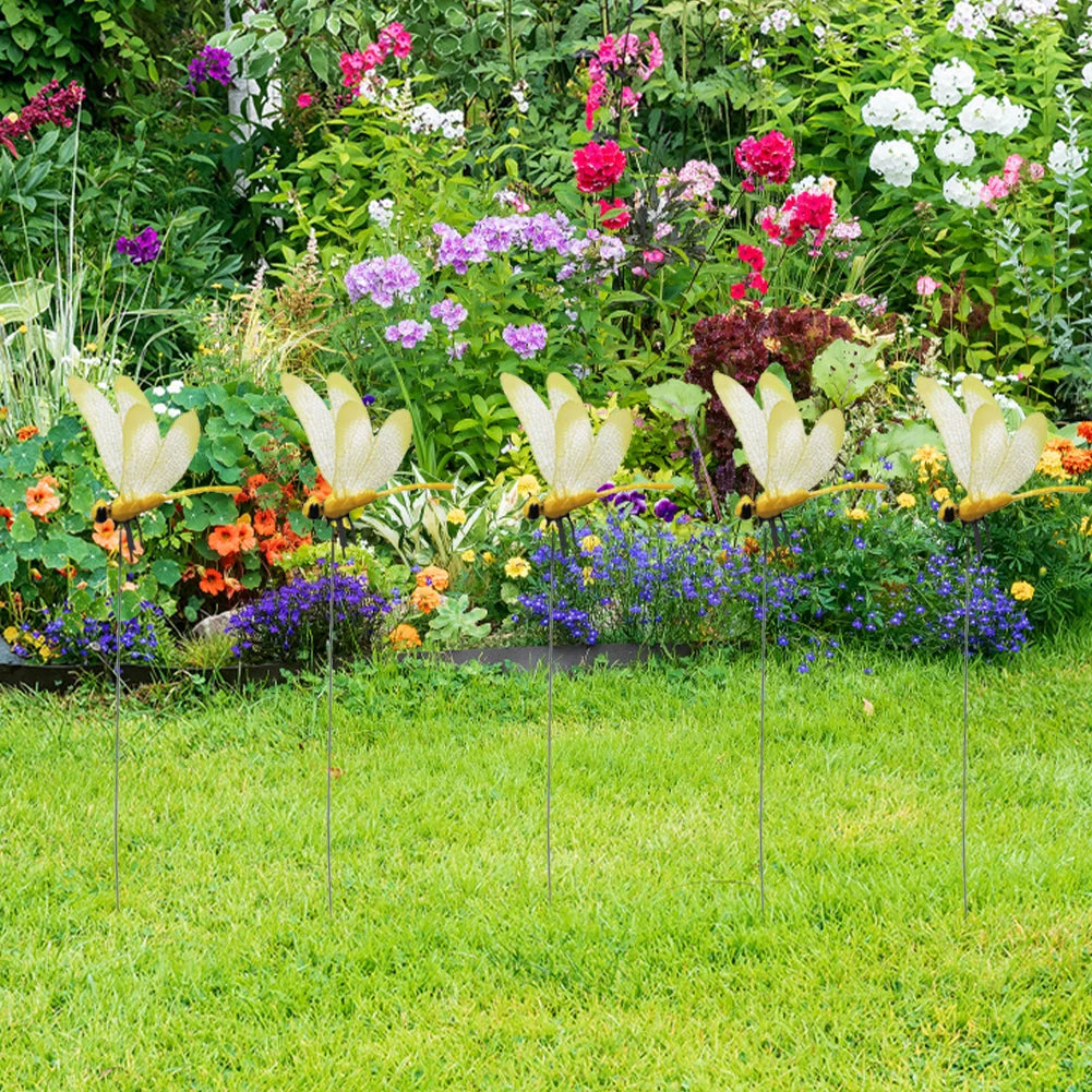 Lifelike dragonfly clips in various colors decorating a vibrant garden flower bed.