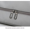 Close-up of a gray fabric travel duffle bag with a silver texture pull head and zipper.
