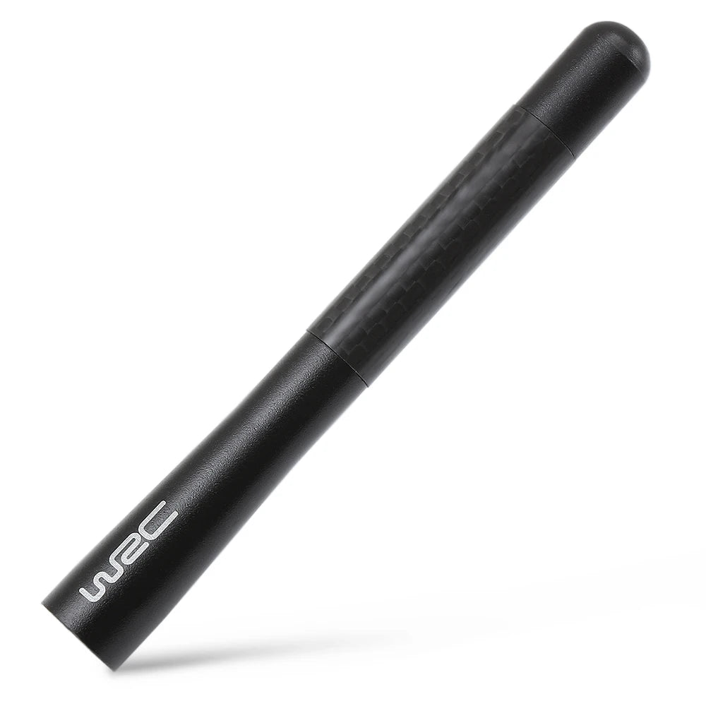 A black carbon fiber short radio antenna with a cylindrical body shown in a diagonal view.