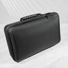 A black portable leather watch travel case with a zippered closure is shown on a white marble surface.