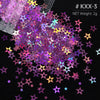 A pile of iridescent holographic star sequins in various colors scattered on a black background.