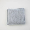 A square, gray needle felting mat made of wool for crafting.