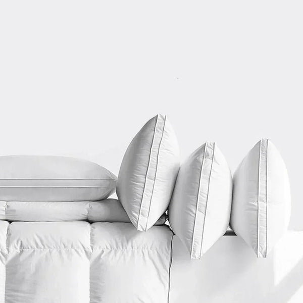 Stapel weiße Luxushotelkissen mit ergonomischer Nackenstütze.