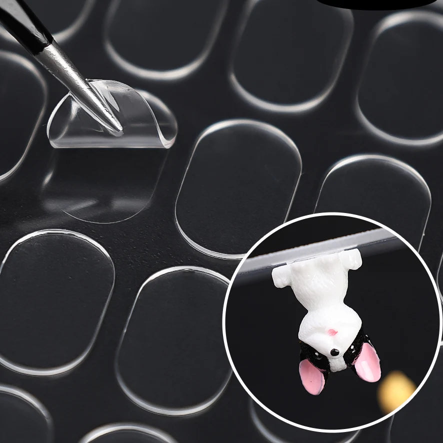 A close-up view of a white mouse patch with black ears and paws resting on a dark surface.