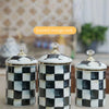 Three enamel storage tanks with a black and white checkerboard pattern on a light background.