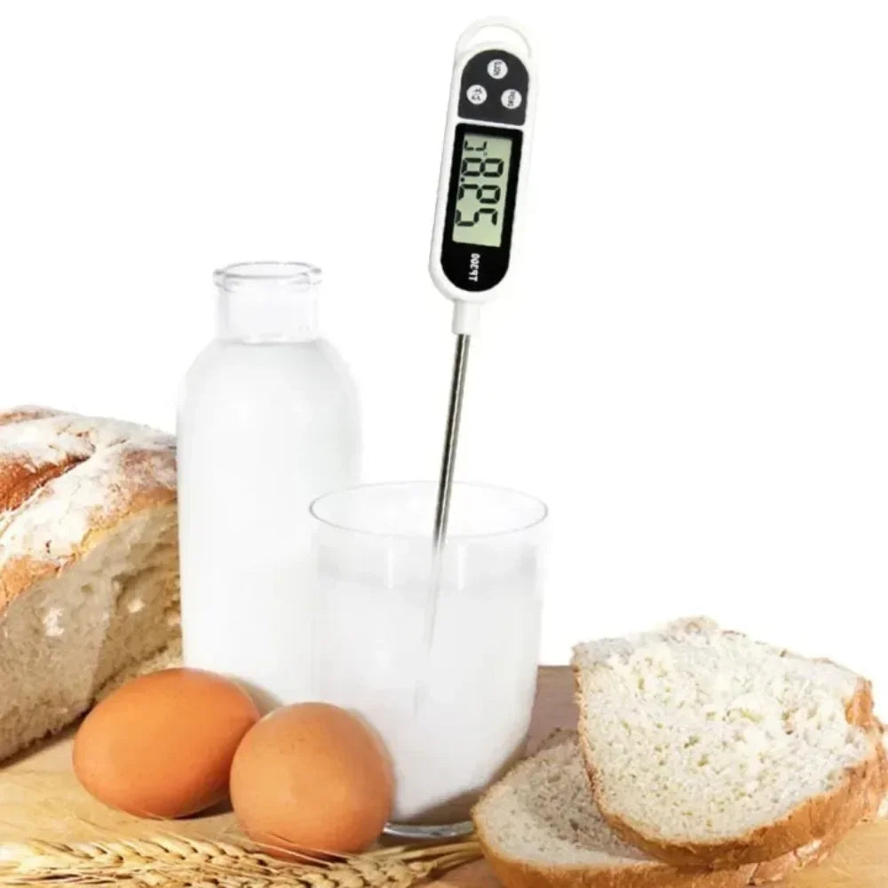 A digital food thermometer with a probe inserted into a glass of milk next to bread and eggs.