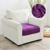 A cream upholstered sofa seat cover with a purple velvet cushion and a purple fabric swirl decoration.