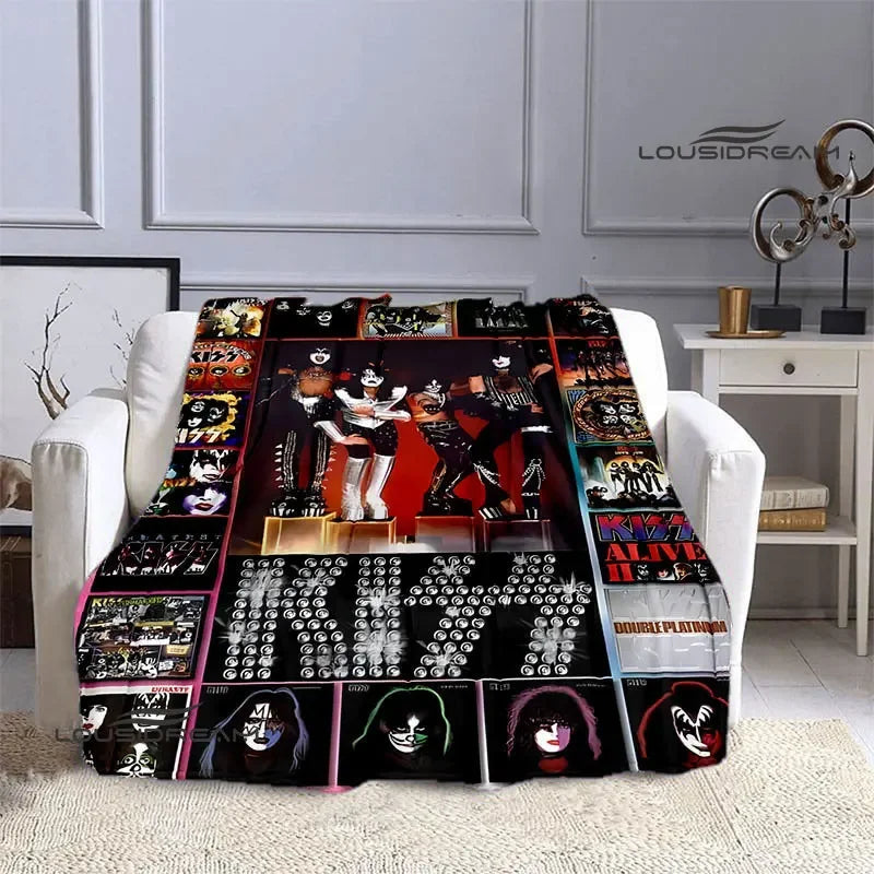 A black and white printed flannel throw blanket featuring various images of the Kiss band members.